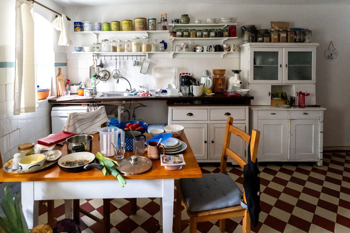 A homey vintage kitchen with dishes, spices, and kitchenware on display, showcasing everyday life.