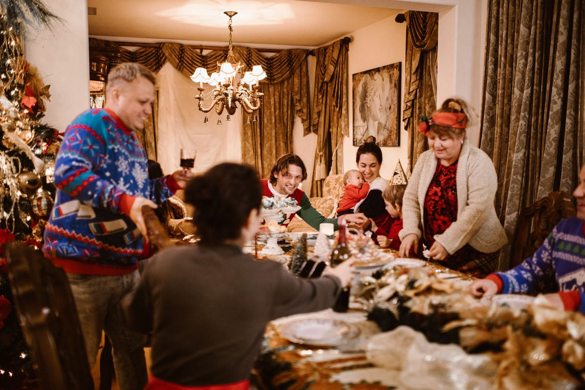A joyful family gathering around a table decorated for Christmas, sharing food and happiness.